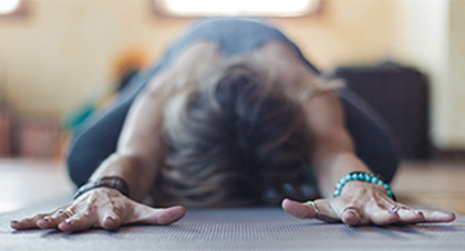 A woman doing a yoga pose on a yoga mat. 