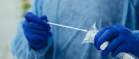 A medical professional preparing a coronavirus testing swab.