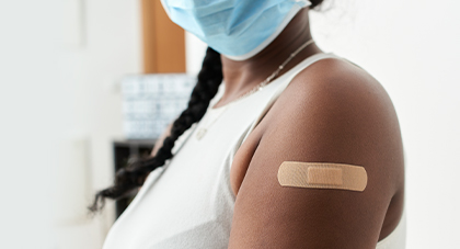 A woman showing off post-shot band-aid on arm.