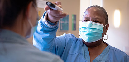 image of a hospital worker taking a patient's temperature