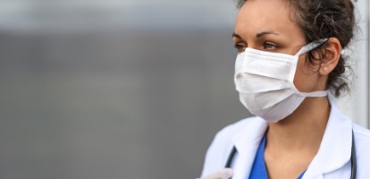 A close-up shot of a female doctor wearing a mask.