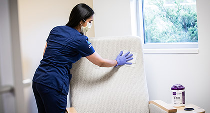 An AHN nurse disinfecting chair between patients.
