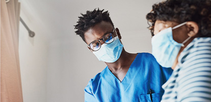 An AHN nurse and patient both wearing masks having a conversation.