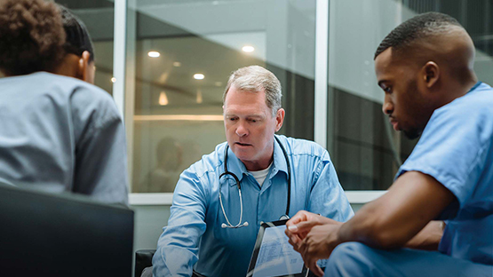 Three AHN physicians collaborating on a patient's care.