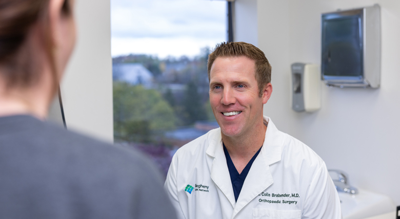 Dr. Brabender consults with a patient in an exam room.