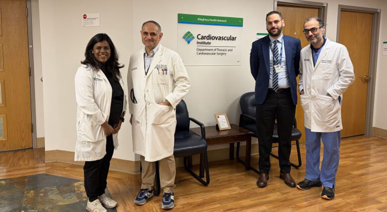 Group of AHN healthcare professionals standing in front of a branded Cardiovascular Institute sign.