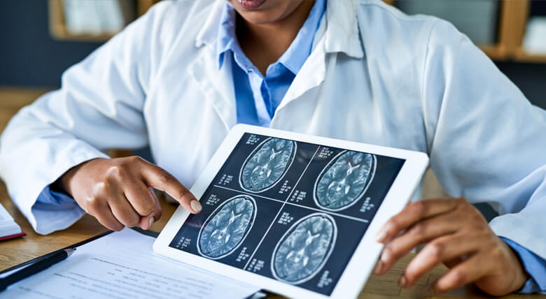 Neurosurgeon showcases brain images on a digital screen.