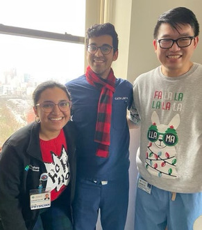 AHN Cardiovascular Disease fellows standing in front of the Marvel graphic novel "The Vitals: True Nurse Stories" by Marvel and AHN.