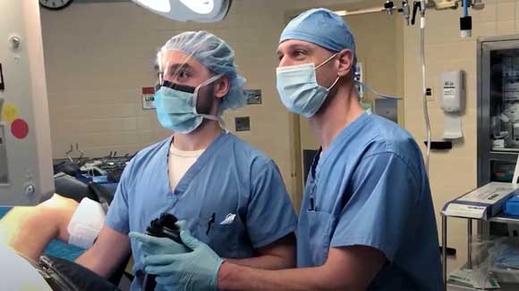 Two surgeons working together on an endocscopic procedure of the colon.