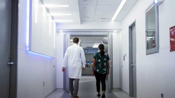 A medical resident and a case manager walking down a hospital hallway