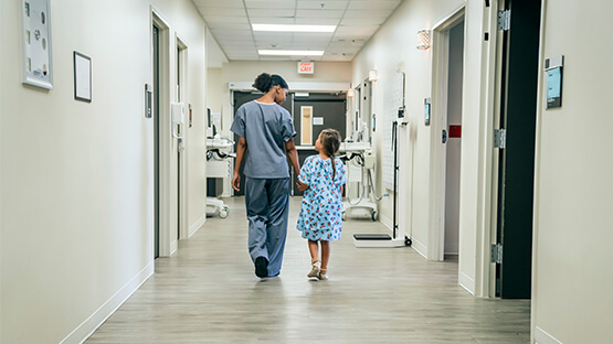 image of a nurse walking with a little girl down a hospital hallway