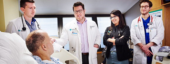 Doctors talking to a patient in bed