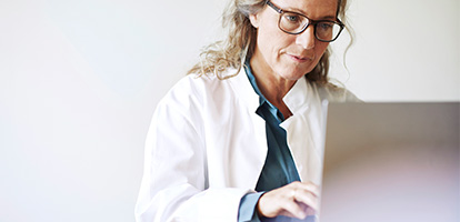 physician researching information into a laptop computer