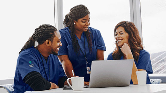 Three nurses looking at a laptop