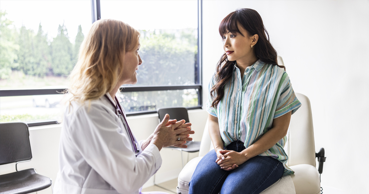 Woman sitting on exam table at doctor’s office