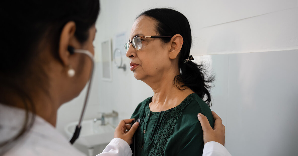 A doctor checking a female patients heartbeat with a stethoscope