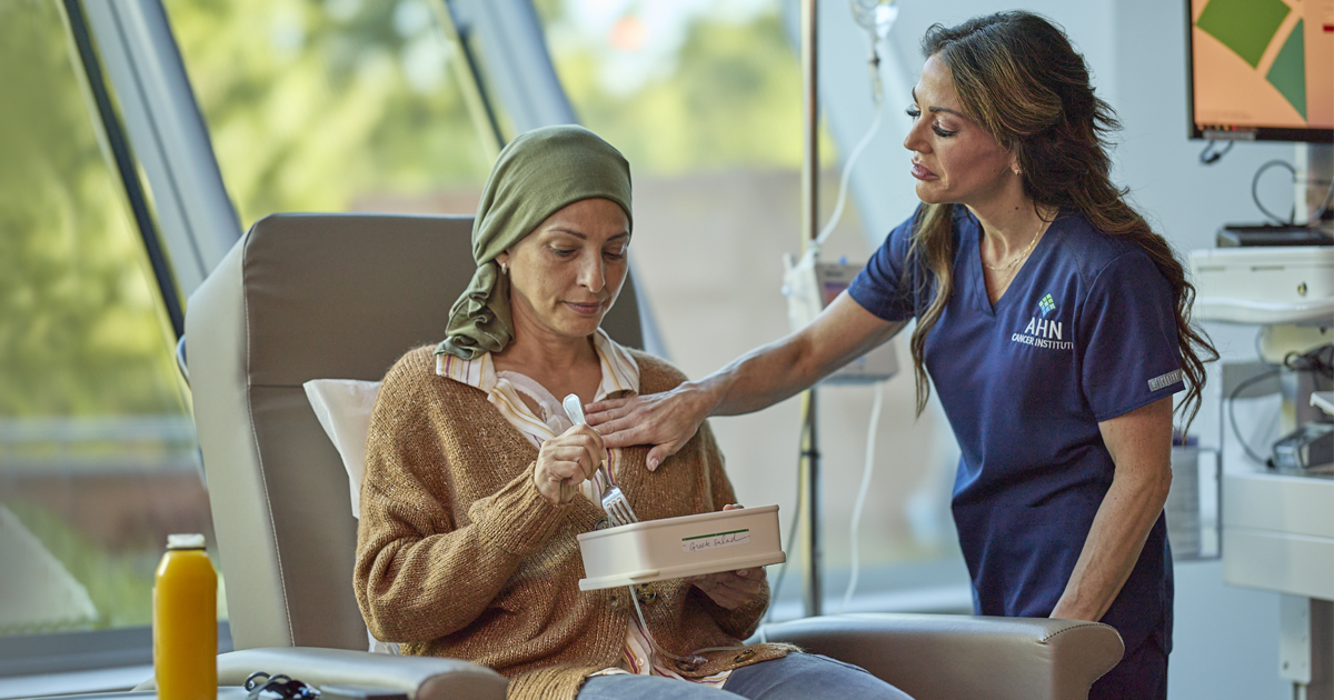 Woman sitting with nurse during chemotherapy
