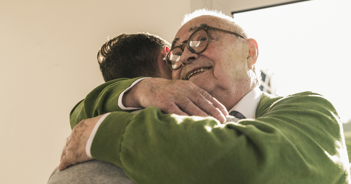 Older man hugging family member