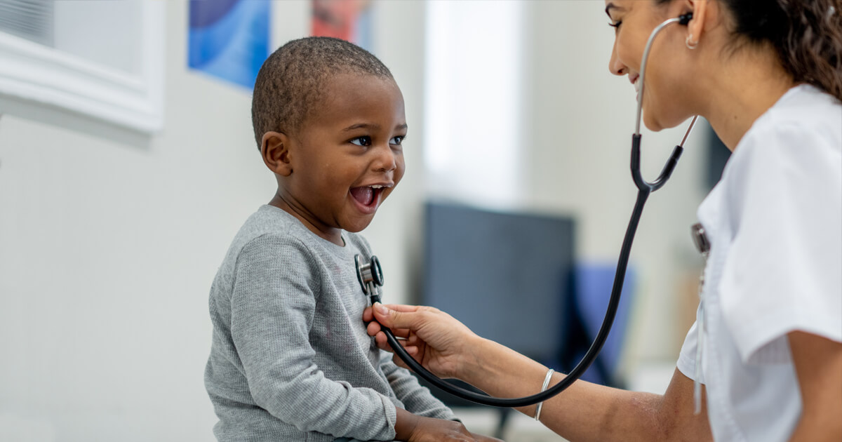 Nurse examining boy with stethoscope