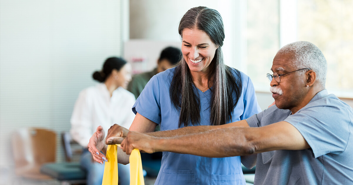 Man using exercise band with medical professional