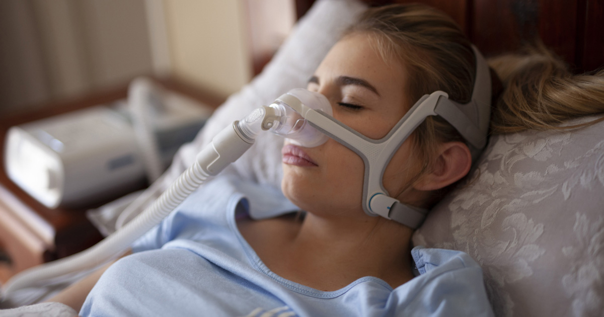 Sleeping woman wearing CPAP machine