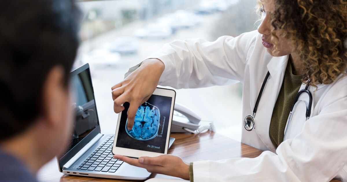 Doctor sharing brain image on tablet with patient