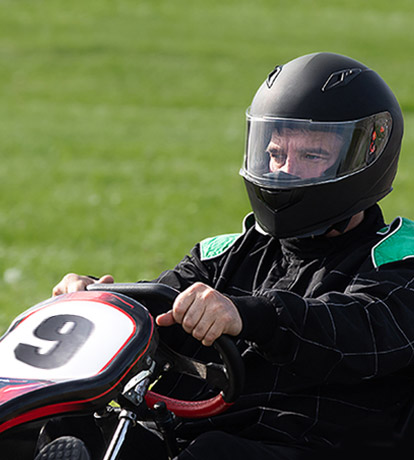 man wearing a helmet and driving a go kart