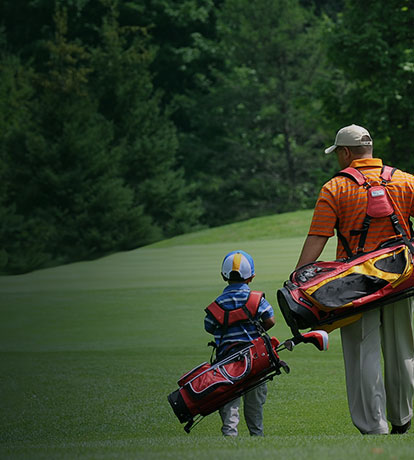 father and son walking on golf course
