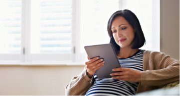 A woman reading on a tablet device.