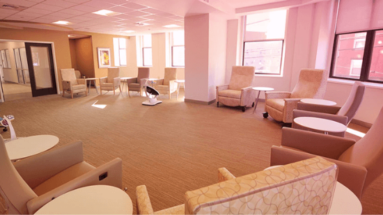 A Group Room at the Alexis Joy Center with comfortable chairs and tables in a U shape along the wall.