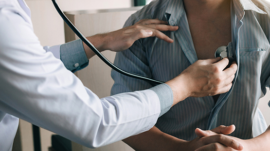 An AHN doctor checking a patient's heartbeat with a stethoscope.