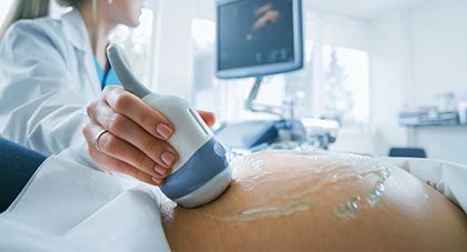 ultrasound technician performing ultrasound exam on pregnant woman