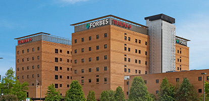A view of Forbes Hospital with a blue sky.