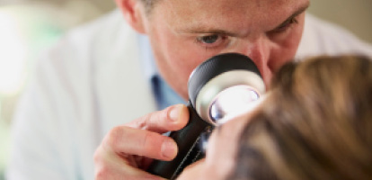Image of a doctor using a tool to examine a patient