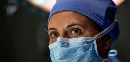 A doctor in an operating room covered in surgical gear