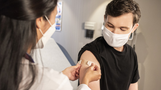 A nurse putting a bandage on a patient who got a flushot.