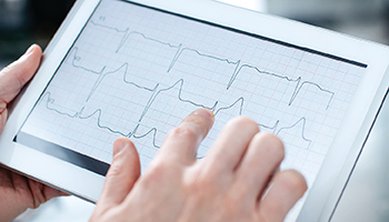 Hands holding a tablet displaying a chart