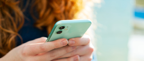 A woman using a phone to schedule her OBGYN appointment online.