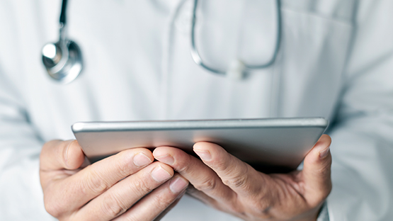 An AHN doctor holding a tablet.