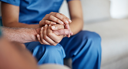 image of a doctor holding hands and comforting a patient