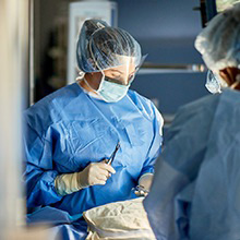 Staff handing surgery tools to the surgeon.