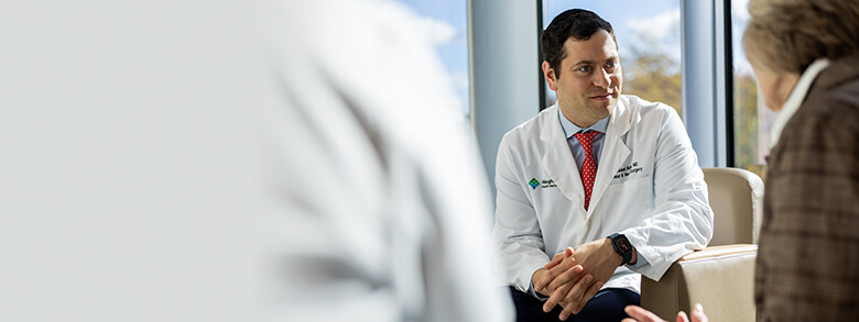 A doctor in a white coat talks to a patient.