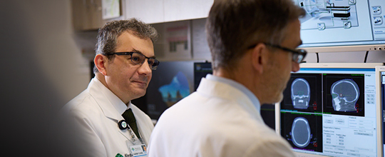 a pair of AHN doctors reviewing a brain scan