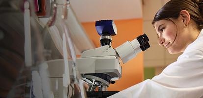 an AHN doctor looking through a microscope