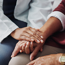 closeup of an AHN medical provider holding hands with a patient