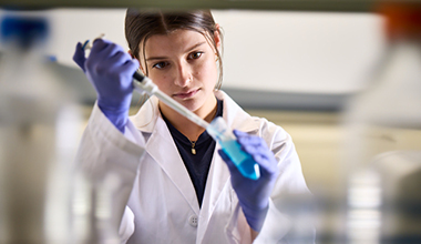 Scientist at AHN working on skin cancer research with vials.