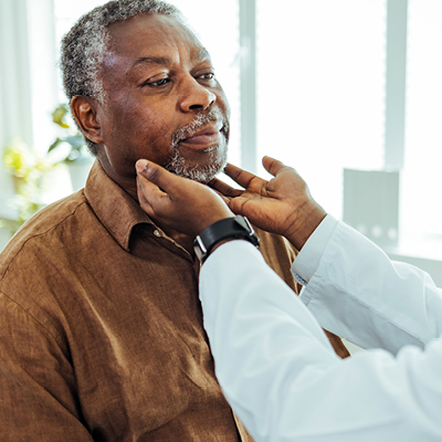 A doctor examining a patient's neck, checking for swollen lymph nodes.