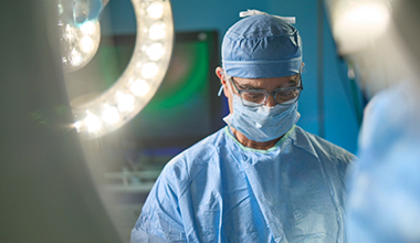 A surgeon wearing surgical scrubs and a mask, ready for surgery