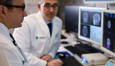 Two doctors review MRI Scans in search of Merkel cell carcinoma.
