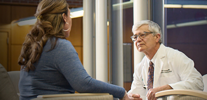 A doctor is in discussion with a female patient in front of a window.
